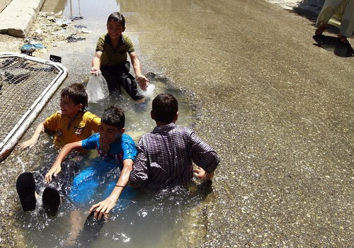 آب تنی کردن کودکان حلب در میان جنگ و خون - عکس از حمید خطیب