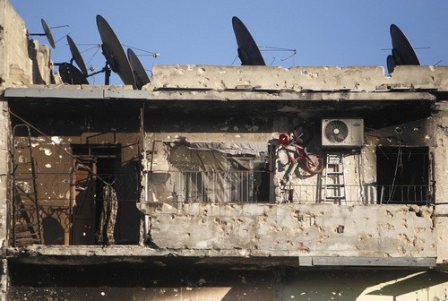 ساختمانی ویران و دیش هایی آباد - عکس از مظفر سلمان