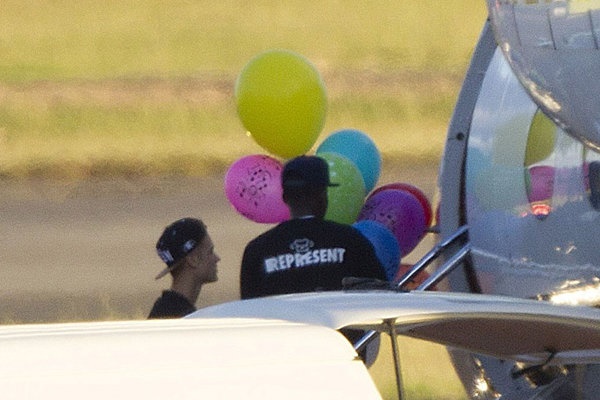 بیبر به همراه بادکنک‌های خود در حال سوار شدن به جت شخصی‌اش در فرودگاه نیوزلند است