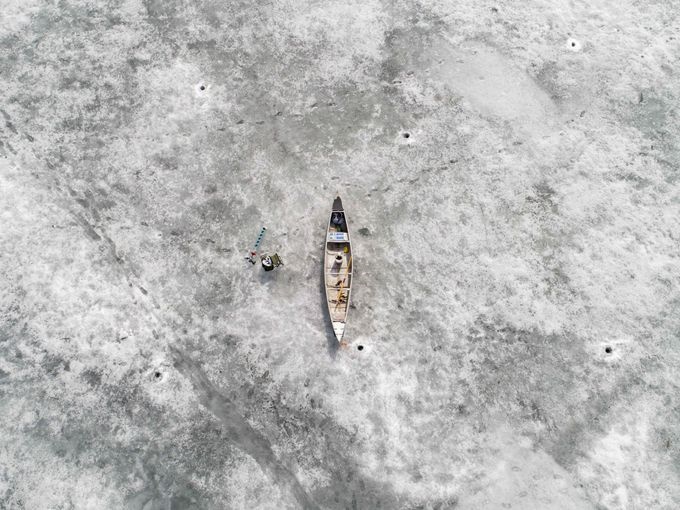 یک قایقران برروی یخ‌های دریاچه‌ای در فنلاند استراحت می‌کند