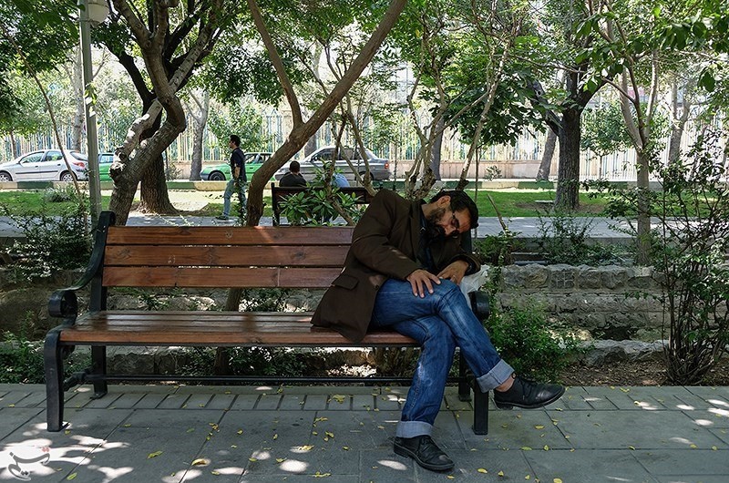 استراحت شهروندان بر روی نیمکت‌های بلوار کشاورز و پارک لاله 
