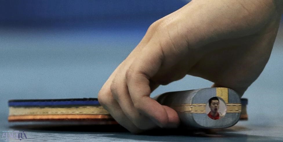 عکس | تصویر ورزشکار چینی روی راکت تنیس روی میزش | ابتکاری که خوش‌یمن بود