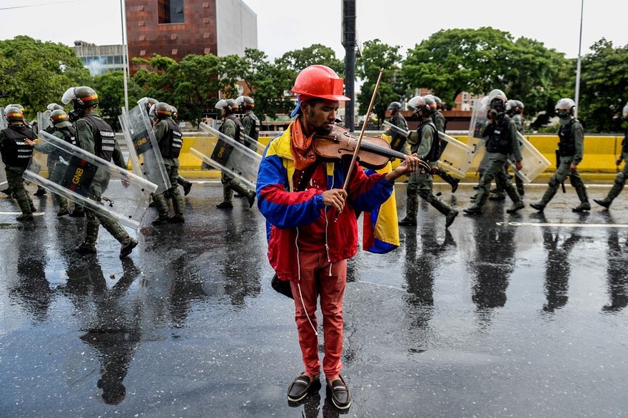 عکس | آهنگ اعتراض ویولون‌نواز ونزوئلایی در میان درگیری پلیس و معترضان