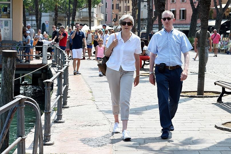 ترزا می نخست وزیر بریتانیا و همسرش هنگام قدم زدن در شهری در شمال ایتالیا
